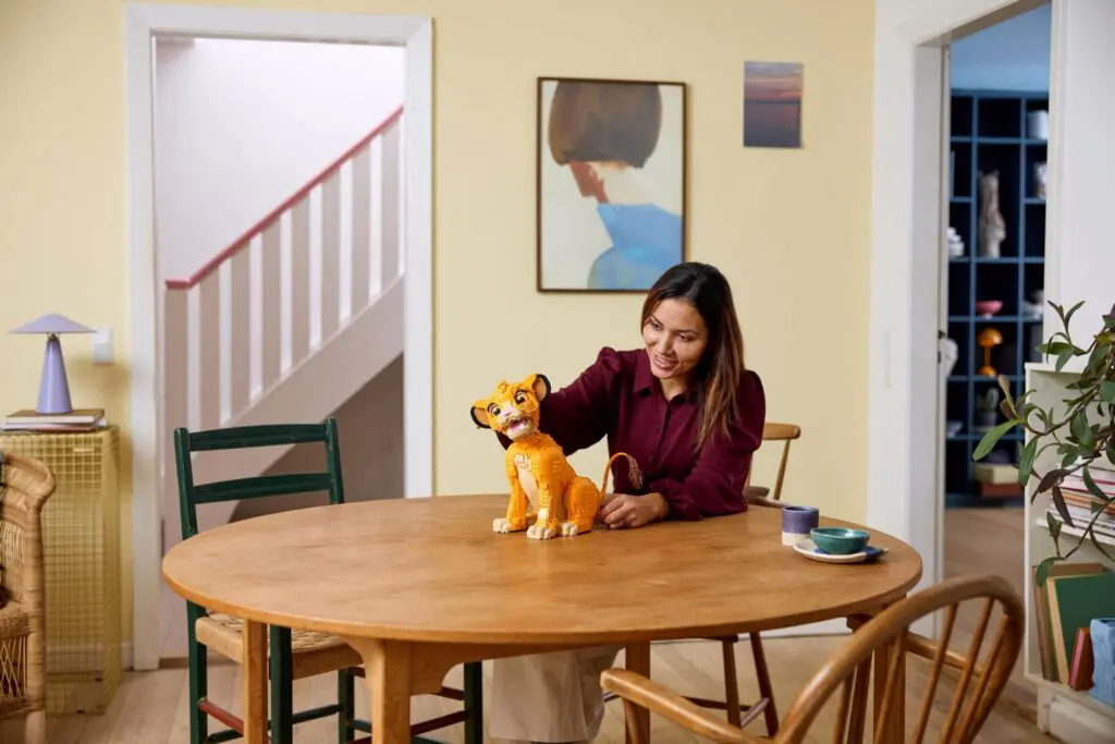 Smiling woman with toy tiger on table
