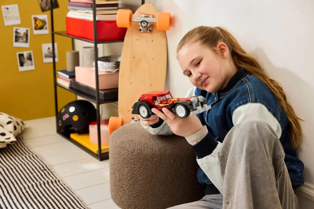 Girl playing with toy car in bedroom