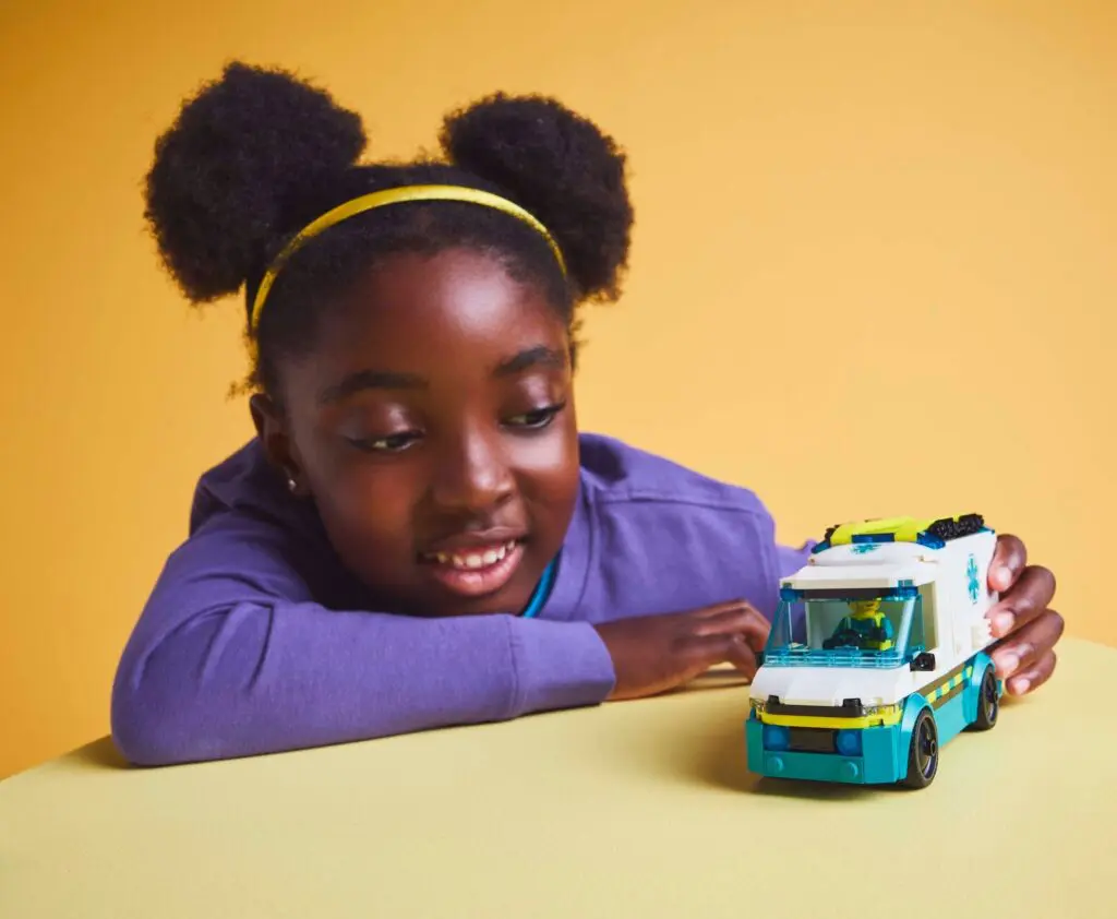 Happy child engaged with colorful toy vehicle.