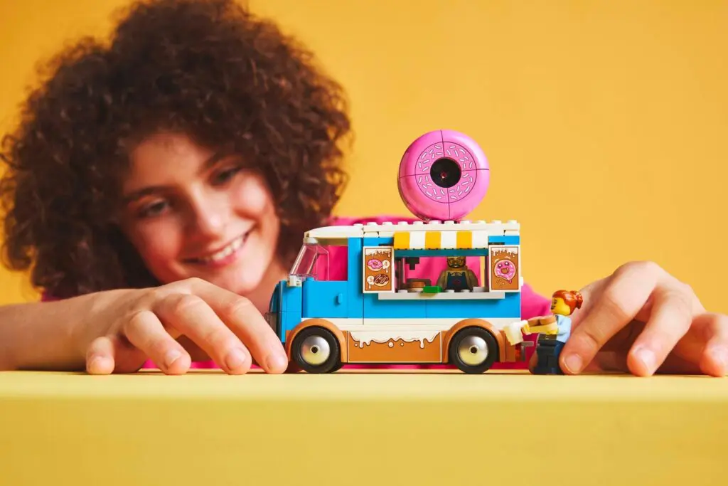 Smiling kid enjoying colorful toy vehicle