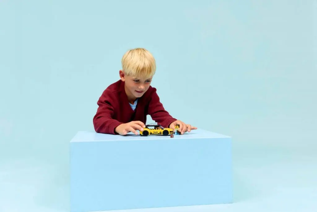 Child playing with toy car on table