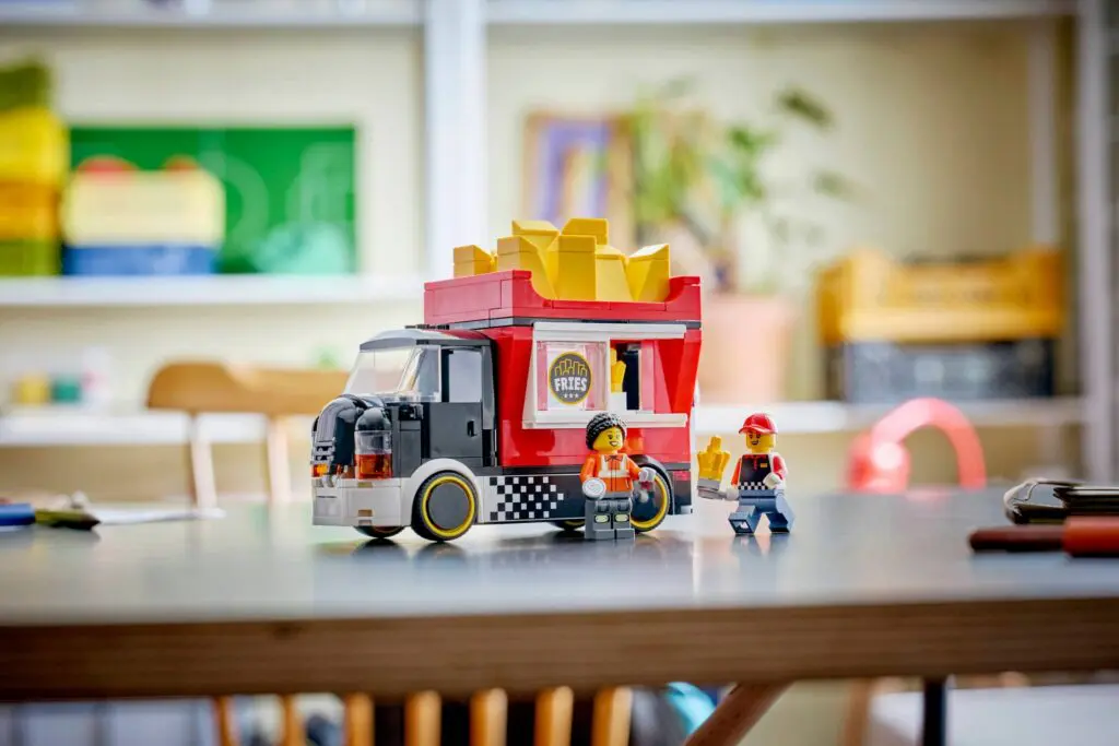 Toy food truck with figurines on table