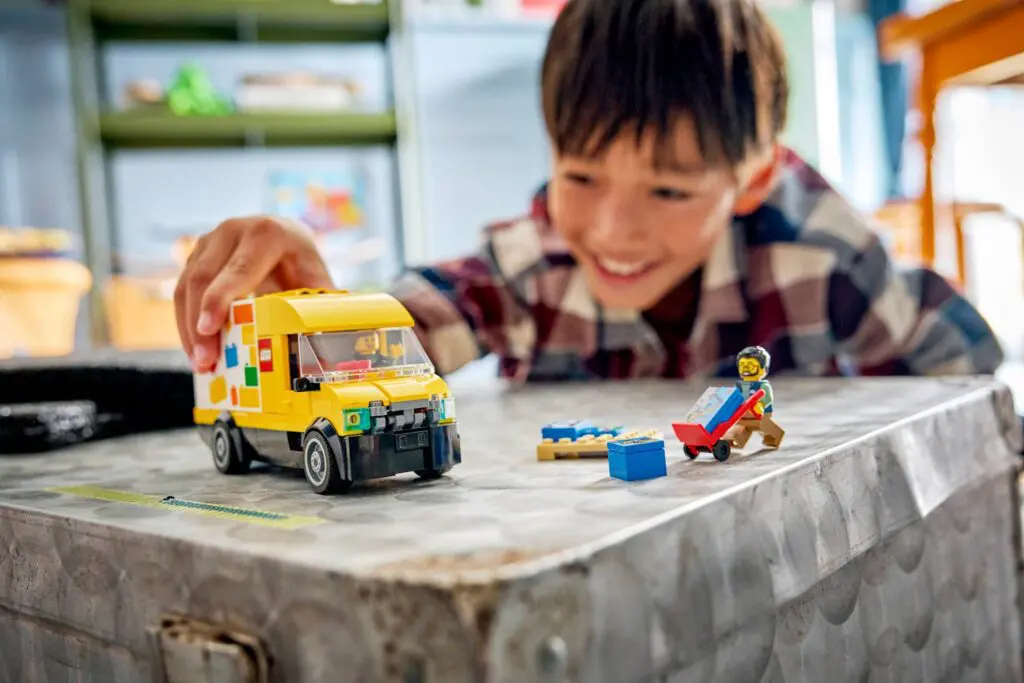 Smiling kid with toy vehicle indoors