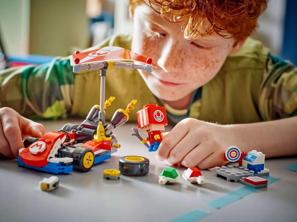 Kid engaged with LEGO and Mario figures