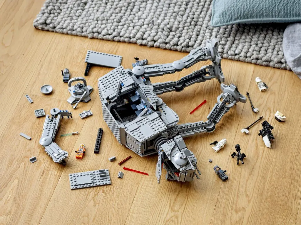 Disassembled LEGO set on floor near rug