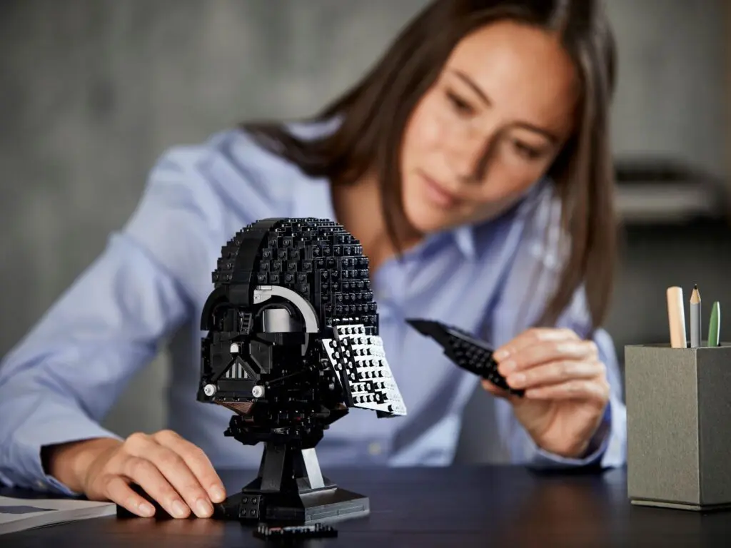 Woman assembling Darth Vader LEGO helmet