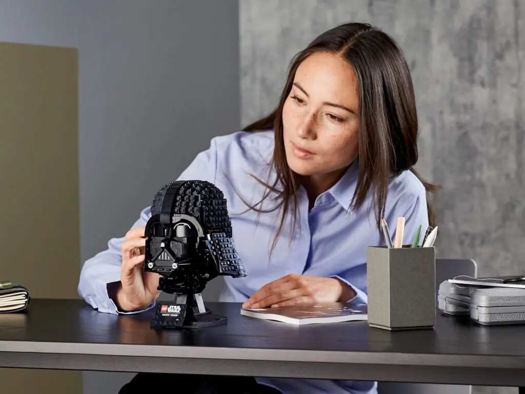 Woman assembling Darth Vader LEGO helmet