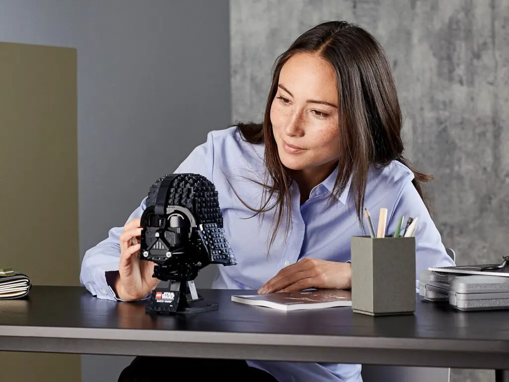 Woman assembling a Darth Vader helmet model