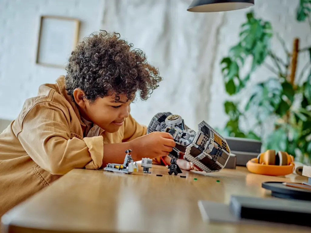 Boy building toy spaceship at home