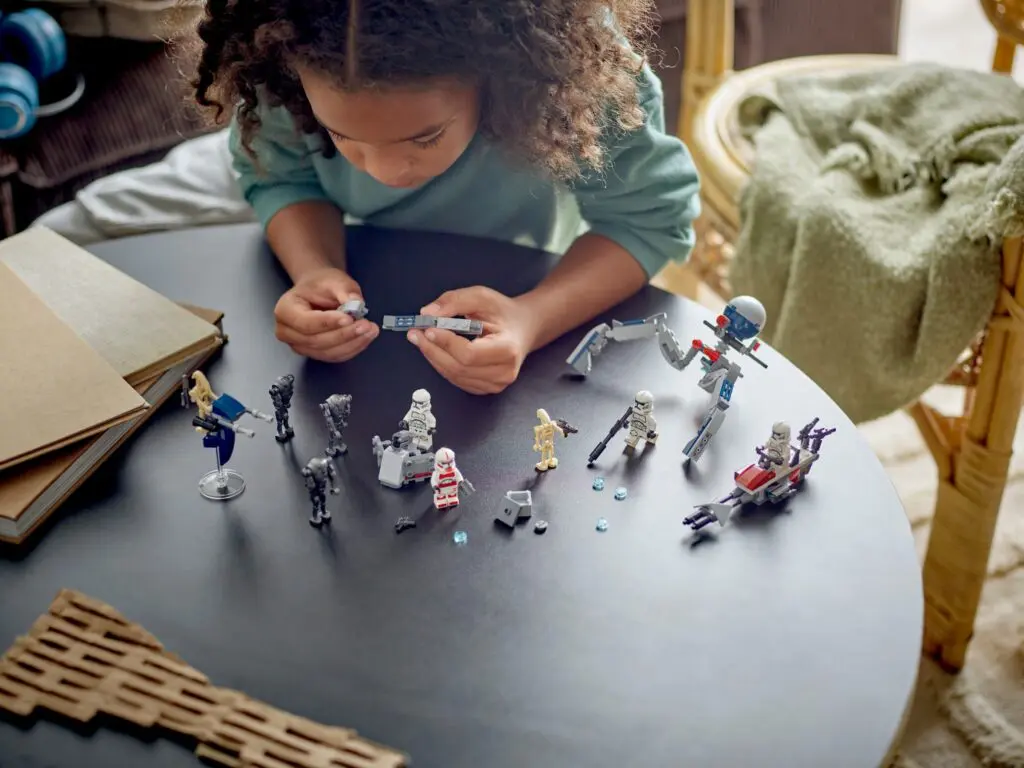Kid engaged with miniature Star Wars models