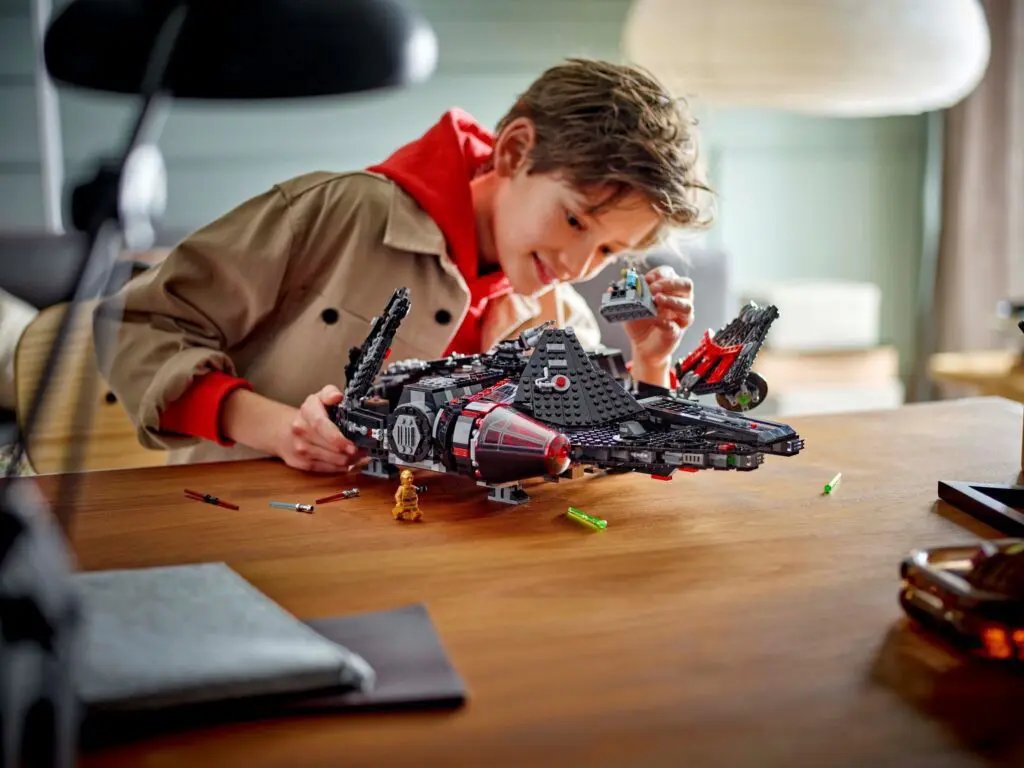 Kid focused on building Lego spaceship