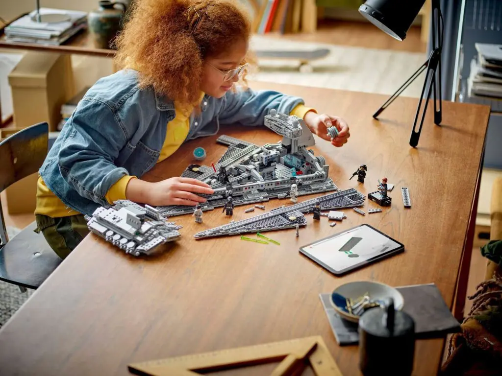 Kid assembling toy bricks on table