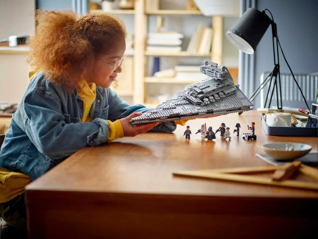 Child playing with spaceship model on table.