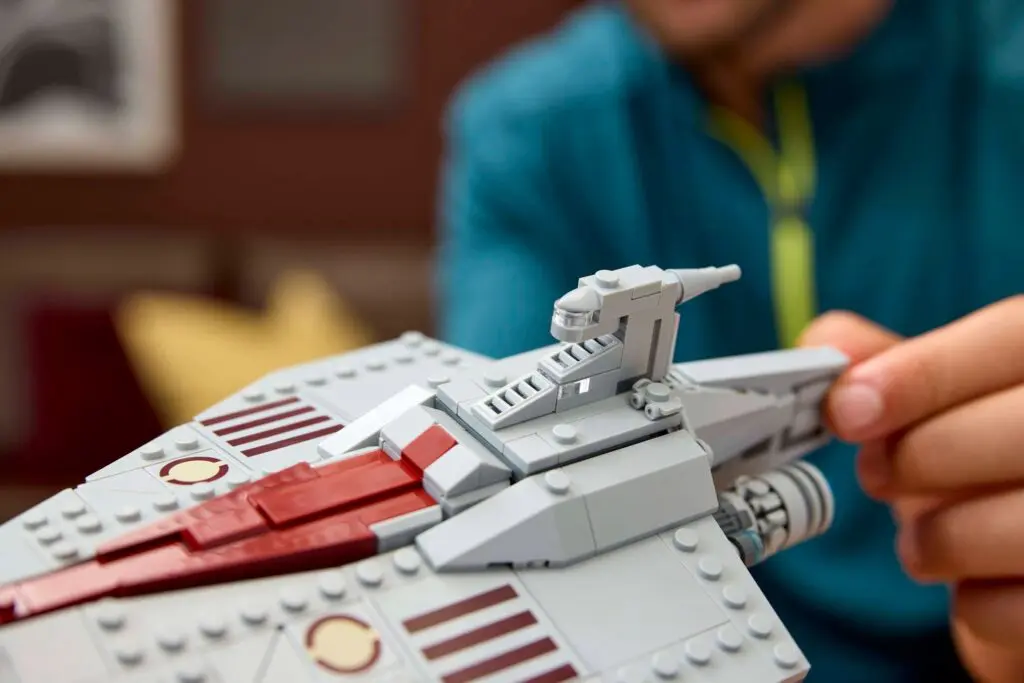 Person assembling a gray spaceship model