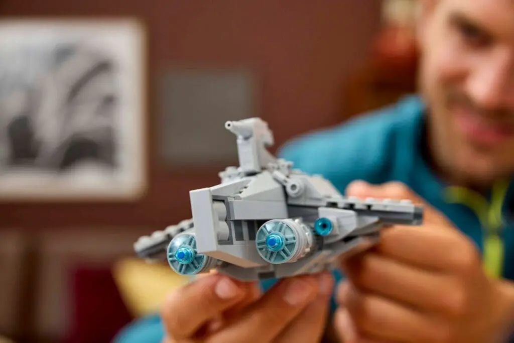 Close-up of hands building LEGO spacecraft