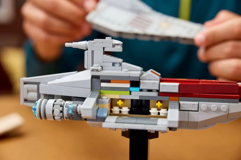 Hands assembling LEGO spaceship model