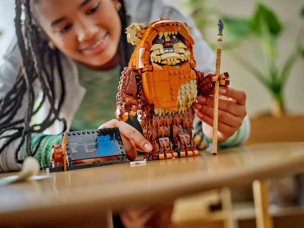 Smiling child assembling LEGO Ewok figure