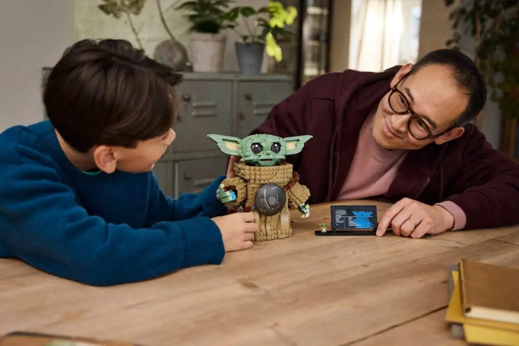 Child and adult with toy on table