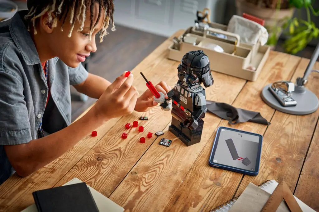 Building LEGO Star Wars model at desk