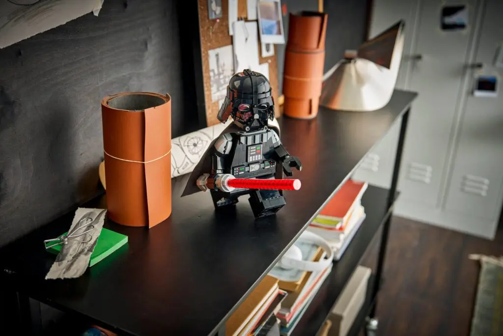LEGO figure with red lightsaber on desk