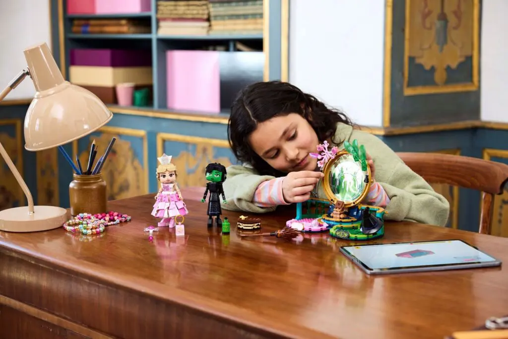 Young girl building toy figures at table