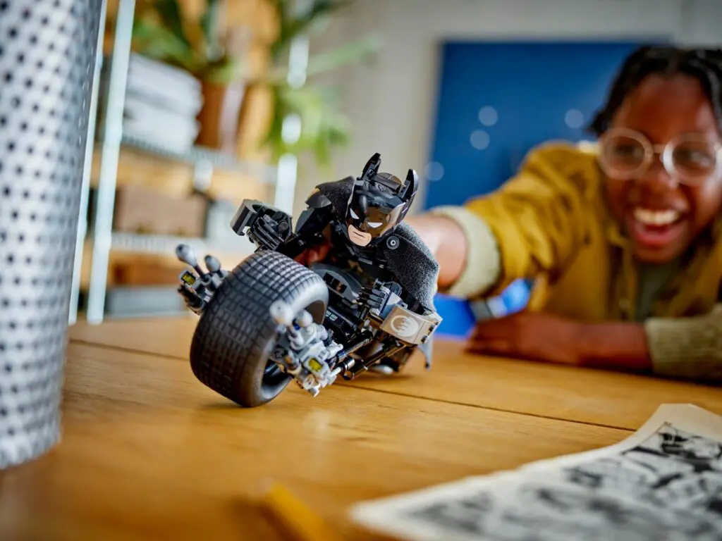 Happy person enjoys toy Batmobile moment.