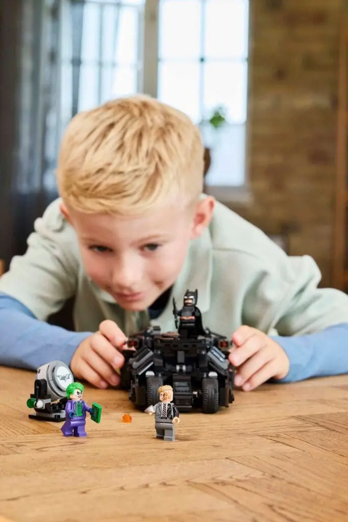 Child playing with Batman LEGO set