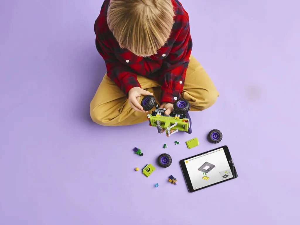 Boy constructing vehicle using instructions app