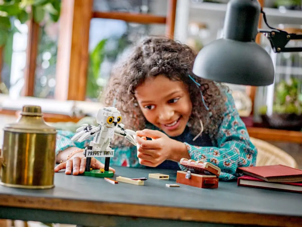 Girl assembling small robot model indoors