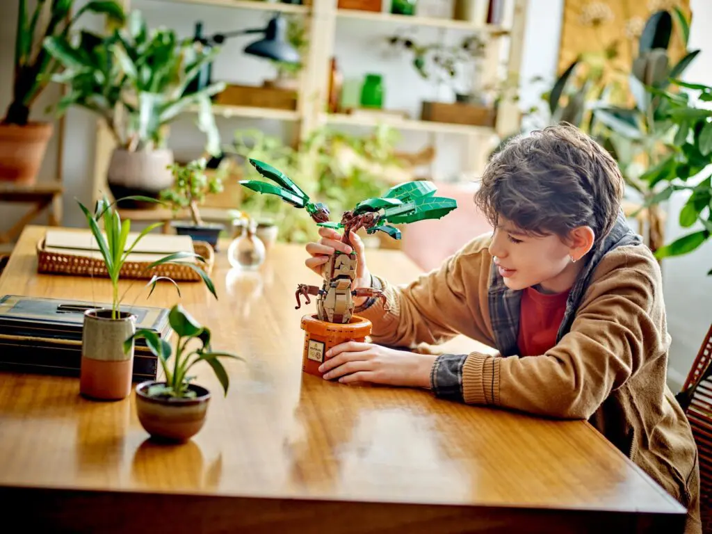 Child playing with LEGO tree on table