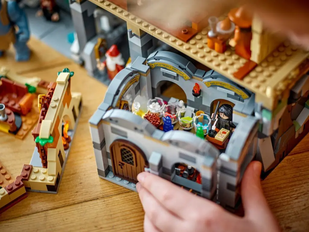 Hands assembling Lego medieval-themed building