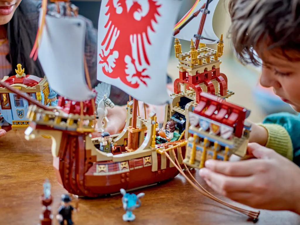 Children playing with detailed pirate ship model.