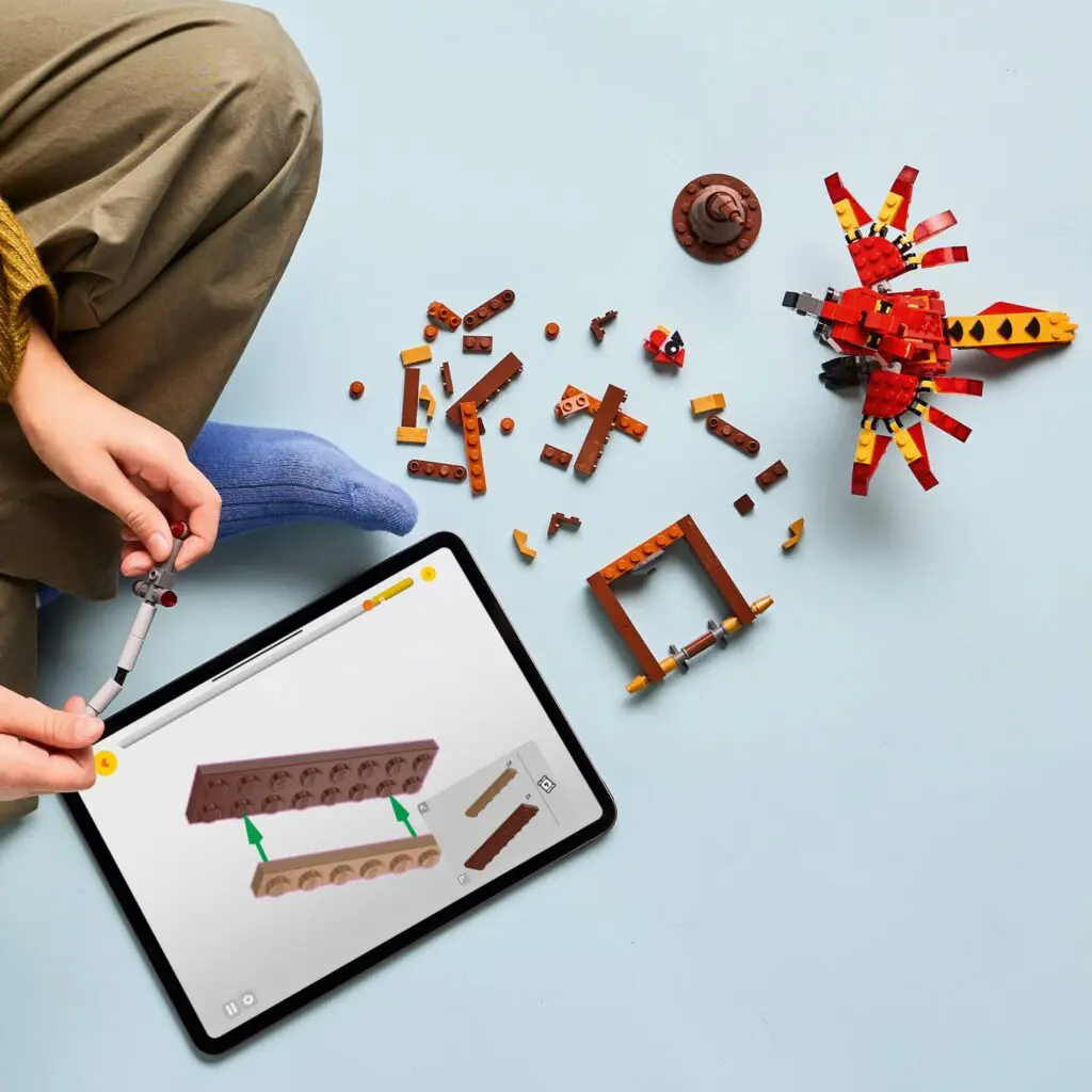 LEGO pieces and tablet on light blue floor