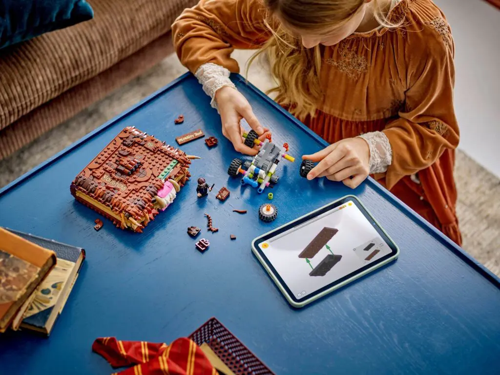 Child assembling LEGO with tablet guide
