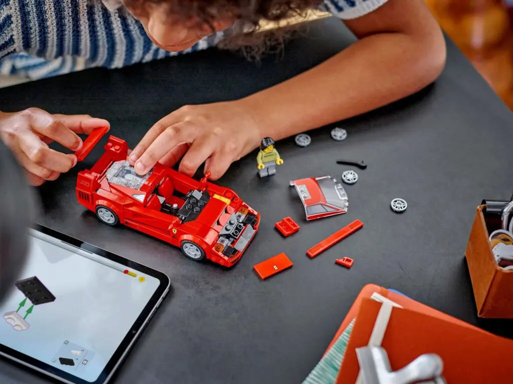 Child assembling red toy car pieces
