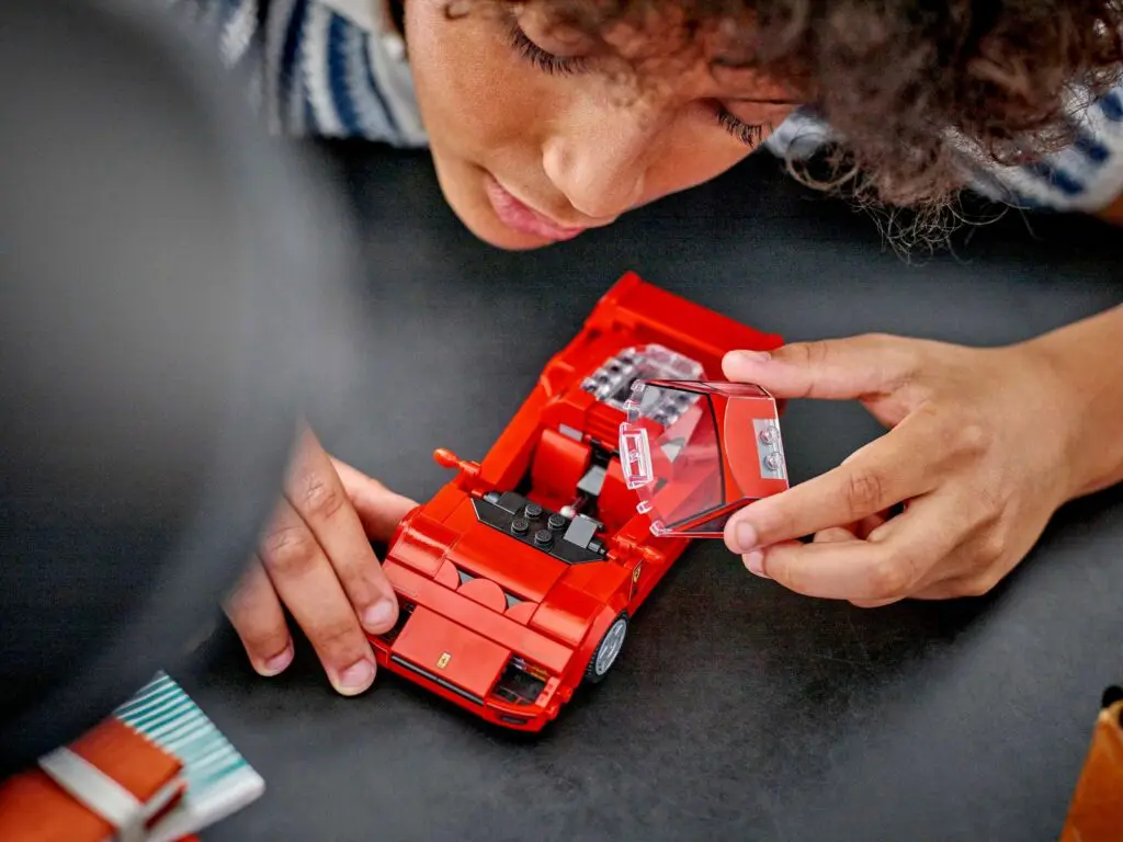Child playing with red toy car
