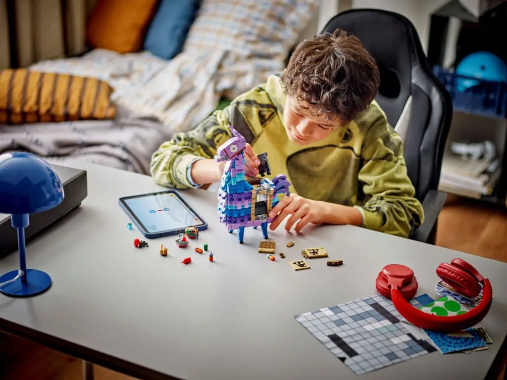 Boy assembling toy with tablet nearby