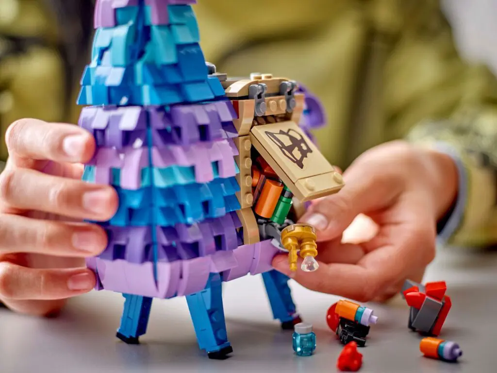 Hands interacting with a LEGO toy llama