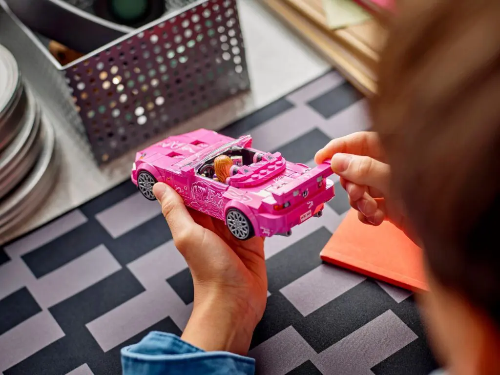 Child holding pink toy car