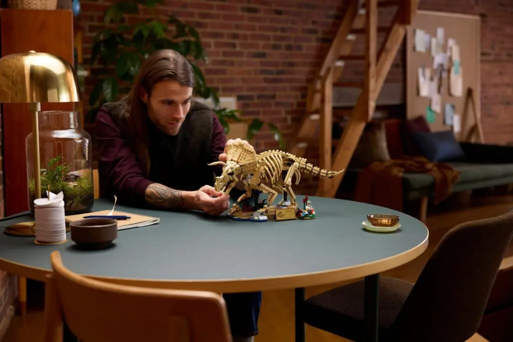 Person building dinosaur skeleton model indoors