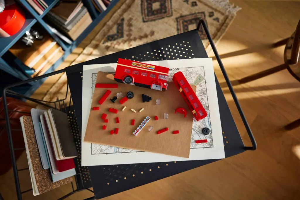 Unassembled red toy bus parts scattered.