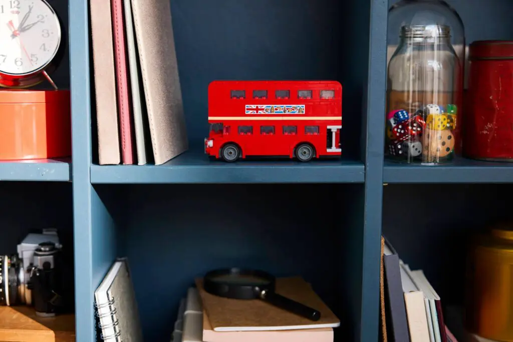 Red toy bus on blue bookshelf