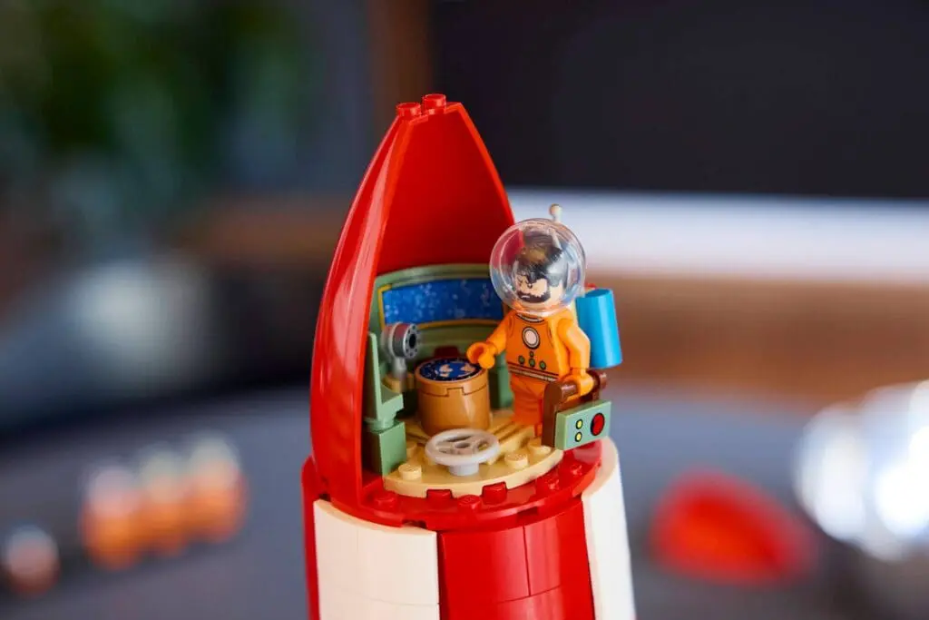 Miniature astronaut in red rocket toy