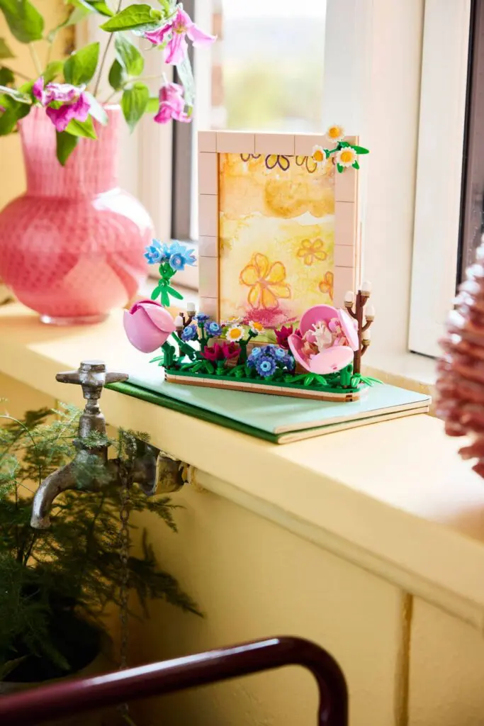 Colorful floral artwork near pink vase