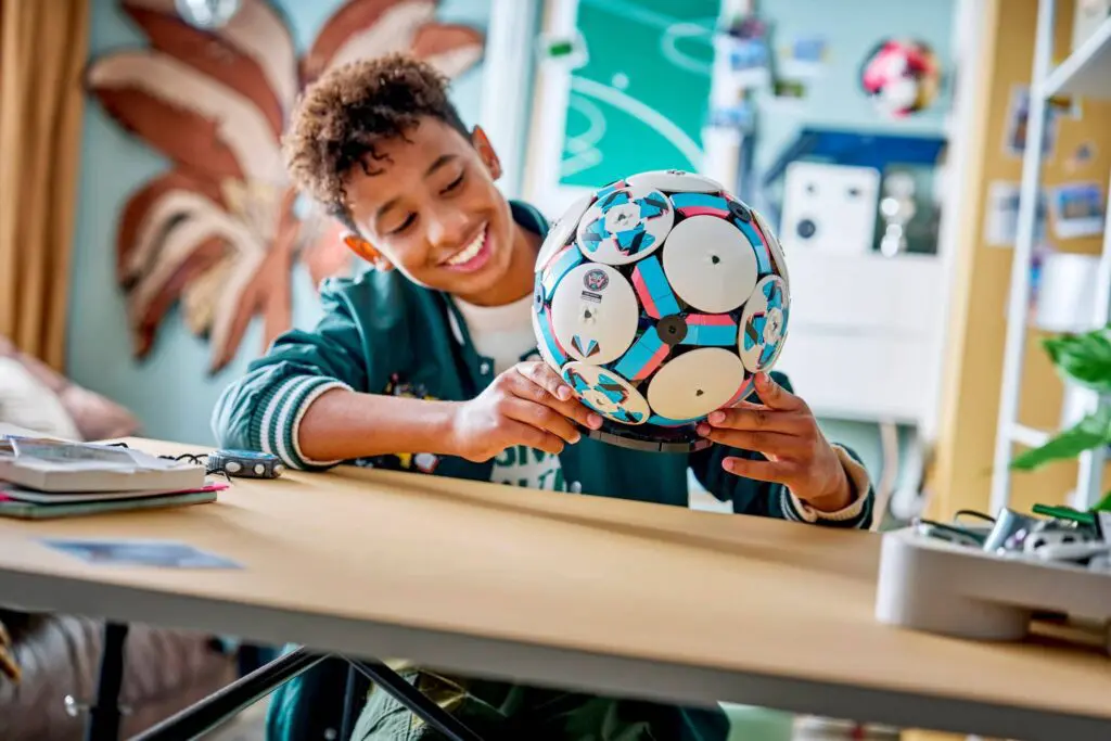Smiling child holding a soccer ball.