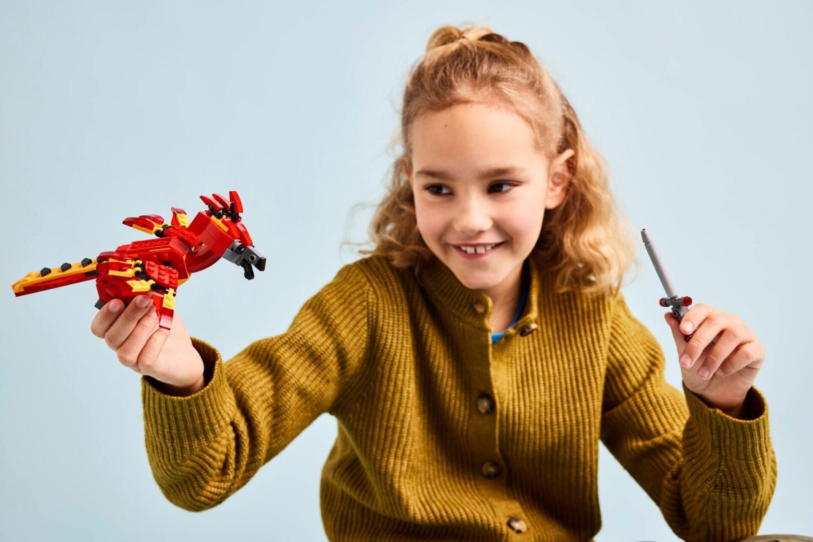 Child playing with toy dragon and sword