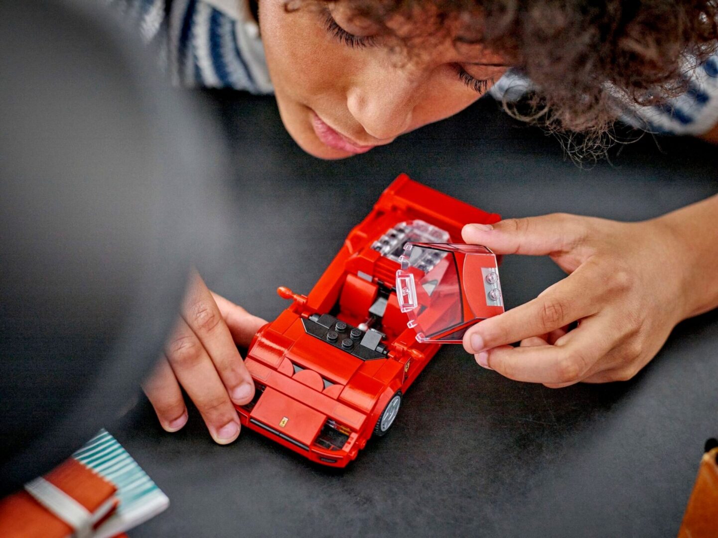 Child playing with red toy car